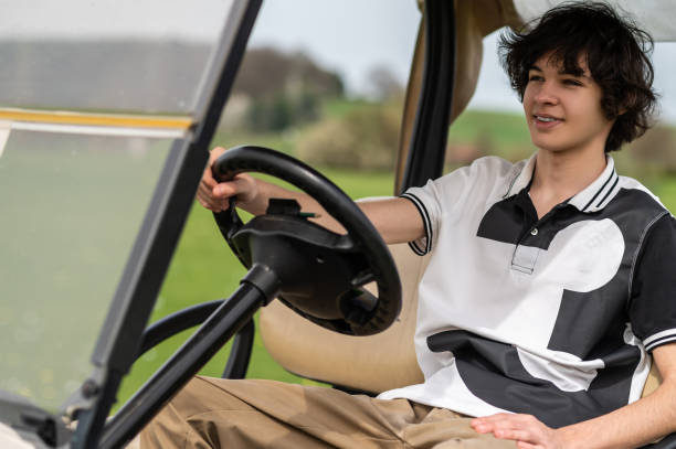 istock Handsome young golfer riding a gold cart and looking contented 2185599487