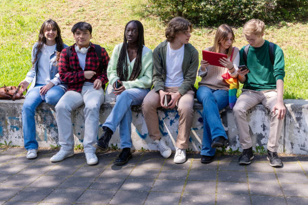 istock Diverse group of Gen Z students relaxing outdoors: multicultural youth and technology 2185600678