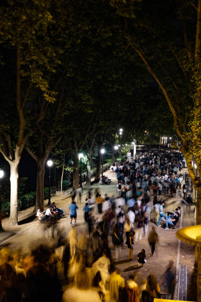 istock Crowd walking in park at night with motion blur effect 2185602408