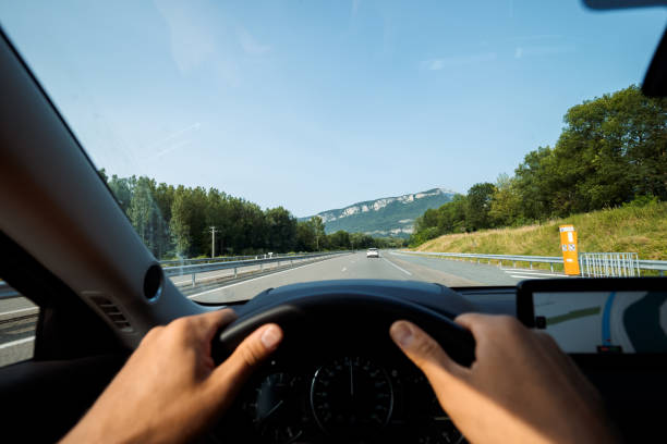 istock Driver holding steering wheel while driving on highway near mountains 2185602415