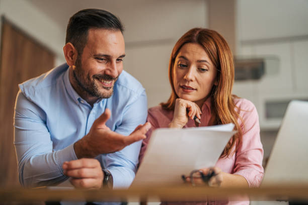 istock A married business couple in the kitchen using a laptop at the table. 2185602496