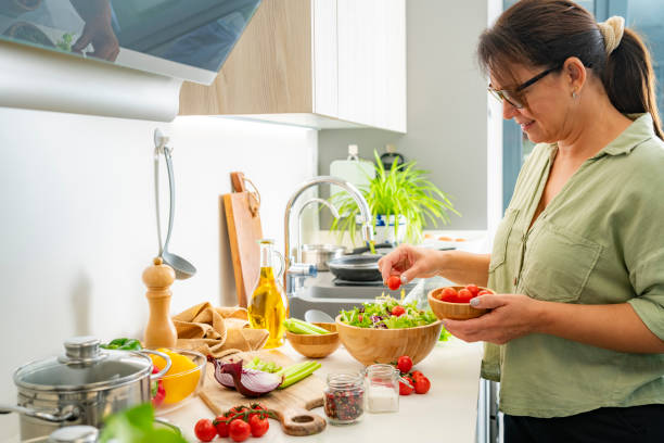 istock Woman prepares a healthy and nutritious vegetables salad using fresh ingredients 2185603180