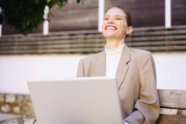 istock A Smiling Businesswoman is Enjoying Her Work on a Laptop While Sitting Outdoors in Nature 2185603366