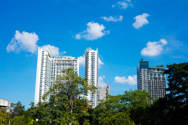 Big apartment towers and condominiums  behind trees of Chatuchak Park in Bangkok. Buildings are located at Phahoinyothin Road opposite to the park