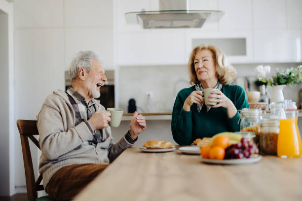 istock Elderly couple using mobile phone over breakfast at home 2185606425