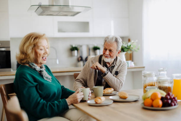 istock Elderly couple using mobile phone over breakfast at home 2185606653