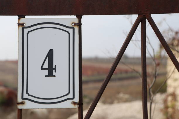 The metal number 4 on a green façade.