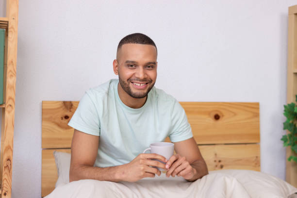 istock Happy man relaxing in bed, enjoying morning coffee 2185607998