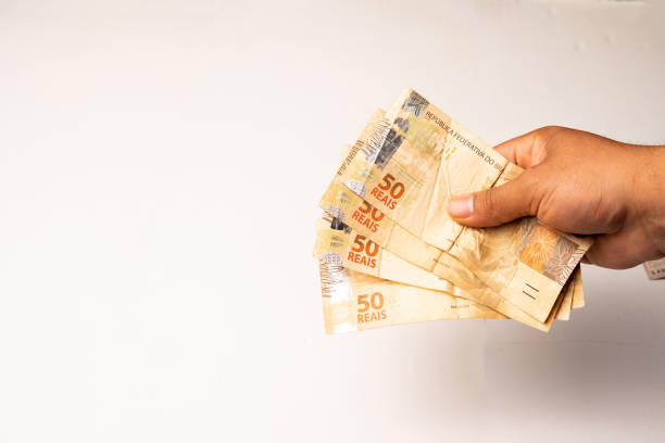 50 reais banknotes in the hand of a person on a white background.