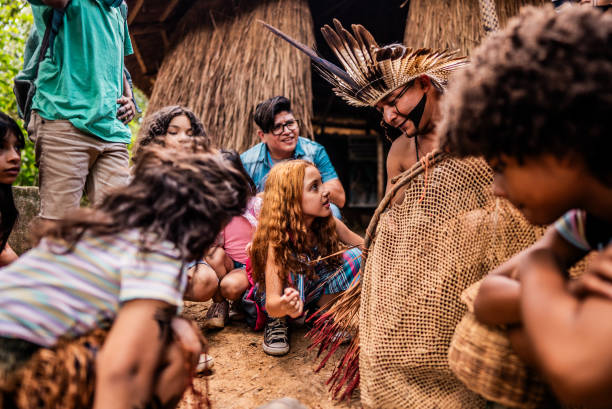 istock Indigenous man talking with children during a field trip to village 2185608588