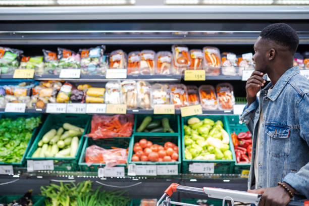 Young handsome African man buying groceries in a local supermarket
