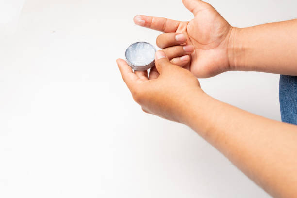istock A hand holding an ointment, arthritis ointment, on a white background. 2185609228