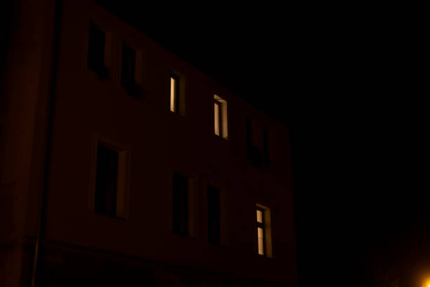 istock Brightly Illuminated Windows on a Dark Night in a City Building 2185609236