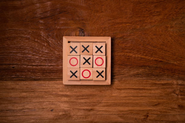 Close-up shot of friends at a cafe playing tic tac toe.