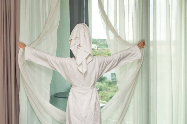 istock woman in a white bathrobe and a towel on her head 2185610654