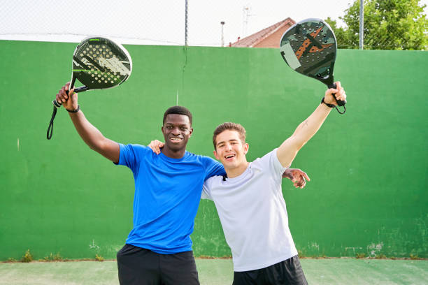 istock Two men are holding paddle tennis rackets and smiling. 2185611703