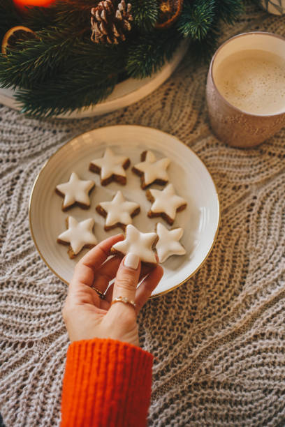 istock Woman picking up star shaped Christmas biscuit from plate 2185613690