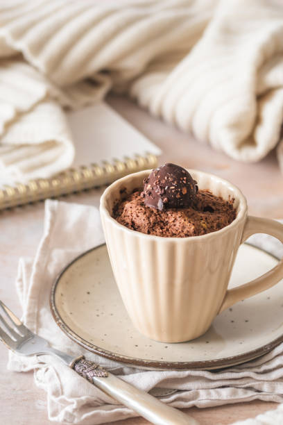 istock Chocolate mug cake with praline topping on creamy white cozy background, vertical 2185615072