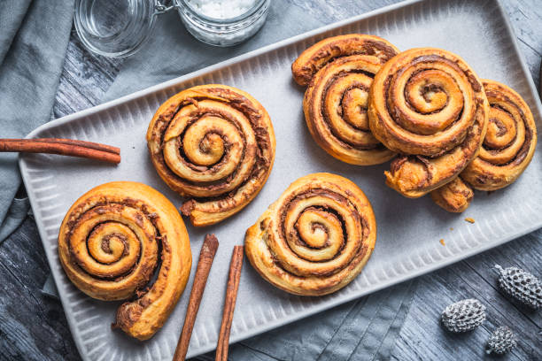 istock Homemade cinnamon rolls on a gray earthenware tray on gray background 2185615122