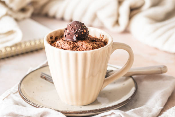 istock Chocolate mug cake with praline topping on creamy white cozy background 2185615127