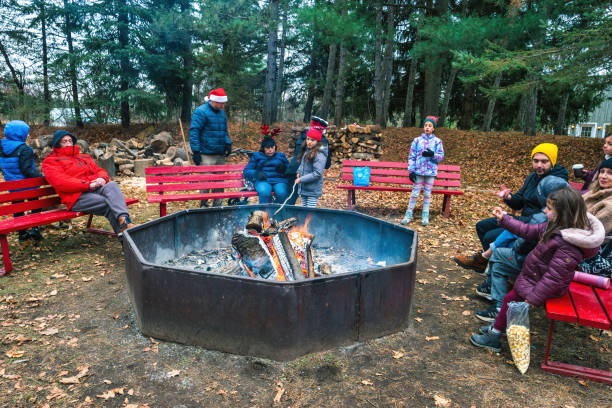 People roasts marshmallows at a Christmas tree farm near Egbert, Ontario, Canada on an overcast day.