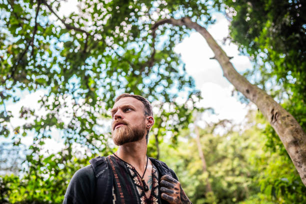Mid adult man looking around exploring tropical rainforest