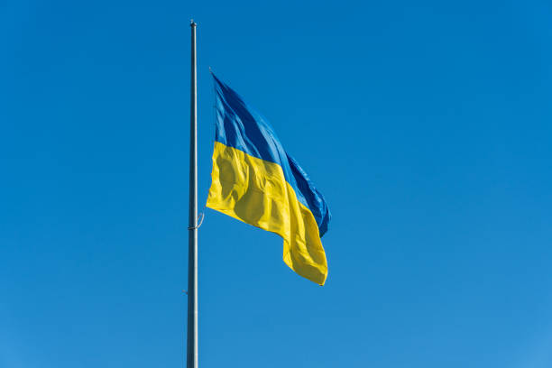 istock A vibrant blue and yellow flag flutters gracefully atop a flagpole, set against the backdrop of a radiant blue sky. The scene exudes a sense of pride and unity, capturing the spirit of a nation 2185617627