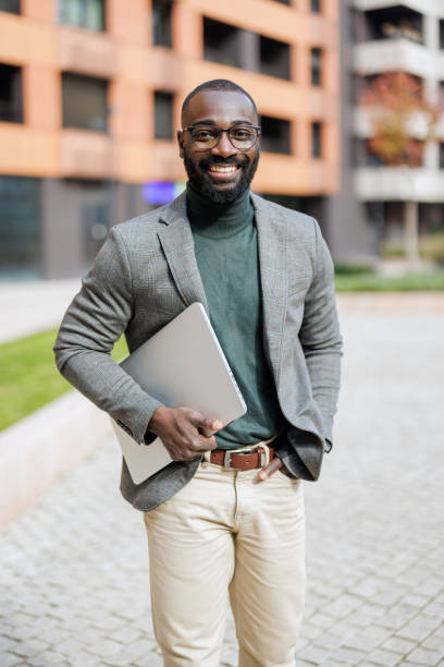 istock Casually dressed man holds laptop near stylish building outside 2185618882