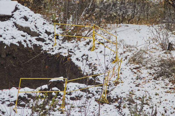 An abandoned construction pit in winter, fenced with construction barriers, neglected development, prolonged construction, close-up.