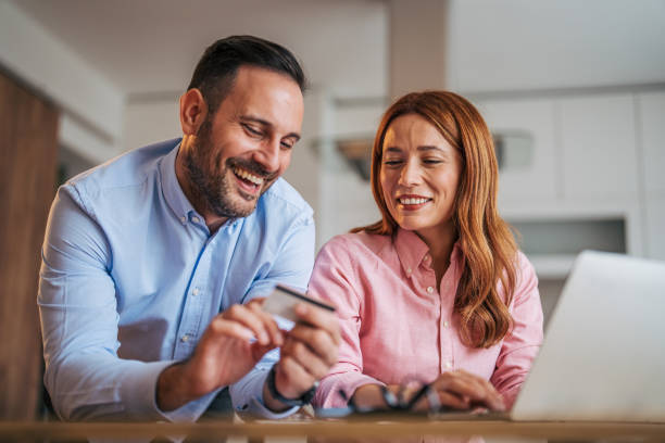 istock A married business couple in the kitchen using a laptop at the table. 2185620843