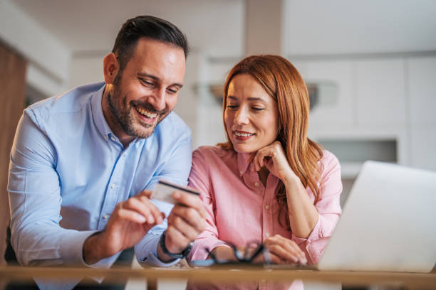 istock A married business couple in the kitchen using a laptop at the table. 2185620982