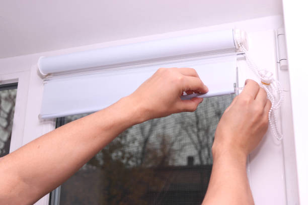 istock Close up of man hands installing roller blinds on the window. Installation of roller blinds. 2185627306