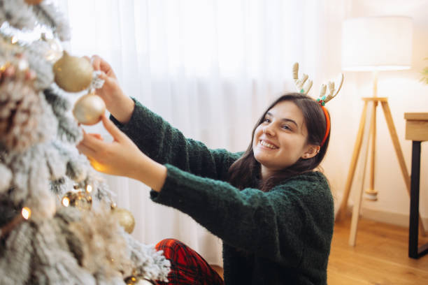 istock Smiling woman hangs a Christmas tree decoration 2185627728