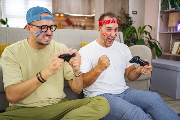 istock Two friends playing video games and having fun at home 2185627922