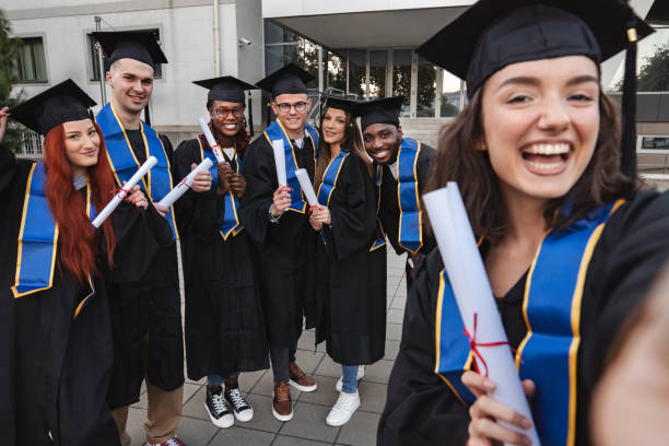 istock Happy graduates taking a selfie after graduation ceremony 2185628321