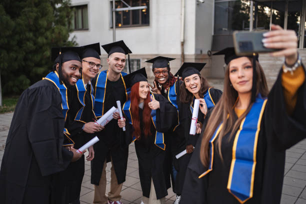 istock Group of graduates taking a selfie after graduation ceremony 2185628393