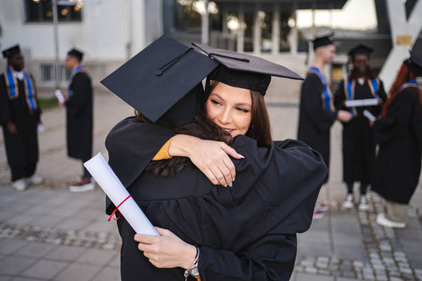 istock Two happy students hugging each other after graduation ceremony 2185628466