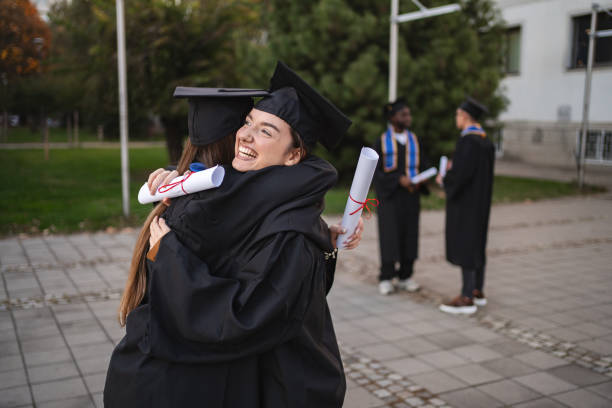 istock Two happy students are hugging each other after graduation ceremony 2185628523