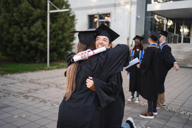 istock Happy students hugging after graduation ceremony 2185628528
