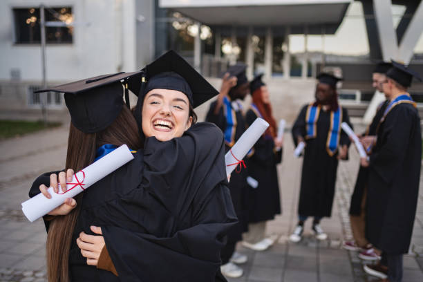 istock Happy students hugging after graduation ceremony 2185628532