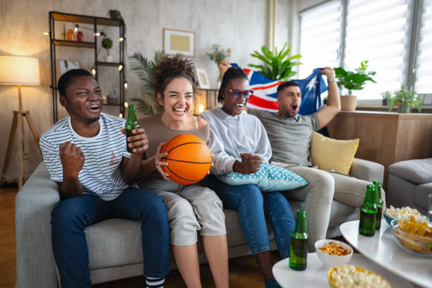 istock Friends celebrating while watching basketball game on tv 2185628644