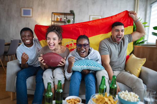 istock Friends holding spanish flag and cheering while watching rugby match 2185628768