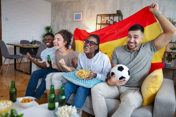 istock Excited friends cheering while watching a spanish soccer match at home 2185628787