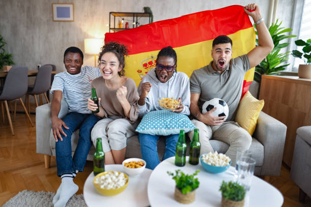istock Excited friends cheering while watching a spanish soccer match at home 2185628811
