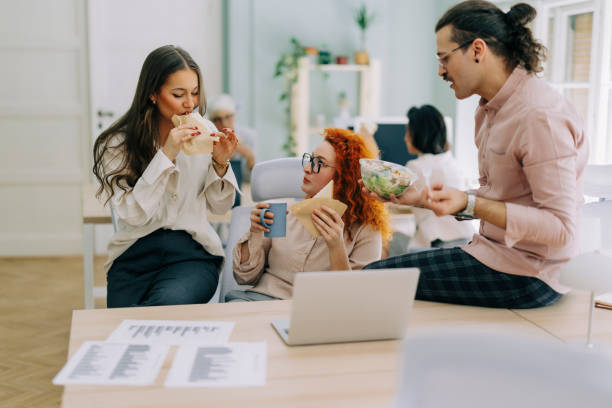 istock Happy colleagues having a lunch break in an office 2185628888