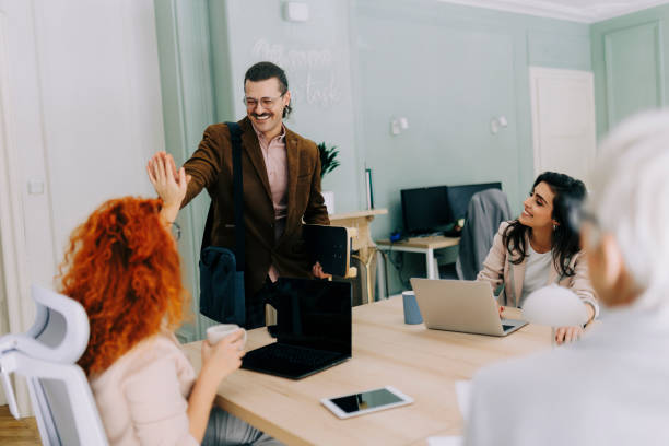 istock Happy businessman waving to someone while entering the office 2185629711