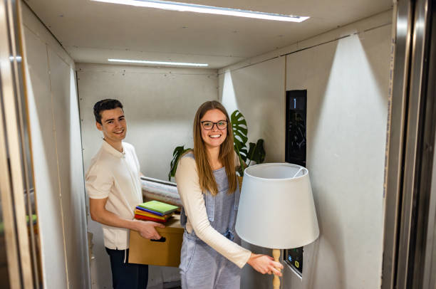 istock Couple Organizing and Transporting Belongings in elevator During Move 2185631069