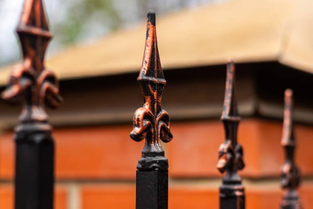 istock A tip on a wrought iron fence. Golden color on a black gate 2185632581
