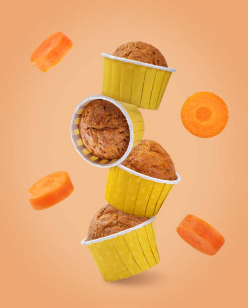 istock Carrot muffin in a yellow paper cup on a orange background 2185634144