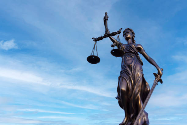 Lady Justice on a Blue Sky Background. There is a lot of copy space to the left.